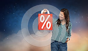 Asian woman with percentage sign on shopping bags