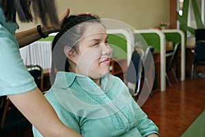 Asian woman a person with blindness disability smiling with happiness when her friend is doing hair arrangement making braids