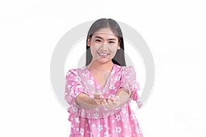 Asian woman in pink dress shows her hand to present something on white background