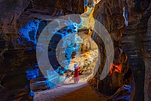 Asian woman in a pink dress visits a blue cave in Tak Province, Thailand