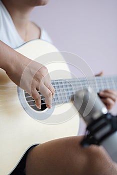 Asian woman play acoustic classic guitar for jazz and easy listening song and record with microphone select focus shallow depth of