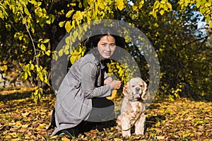 Asiatico una donna giocare il cane autunno 