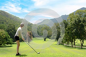 Asian woman playing golf on a beautiful natural golf course