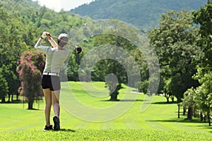 Asian woman playing golf on a beautiful natural golf course