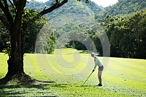 Asian woman playing golf on a beautiful natural golf course