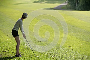 Asian woman playing golf on a beautiful natural golf course