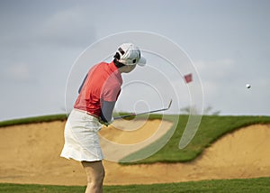 Asian woman playing golf outdoors in course in summer