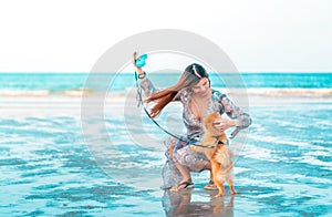 Woman is playing with her pet dog on a summer beach, for Animal loving and relaxing cocnept photo