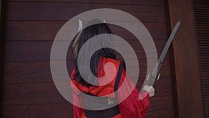 An Asian woman playing with the silver sword before the battle with her rival