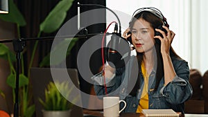 Asian woman podcasters using laptop and condenser microphone to recording podcast in home studio