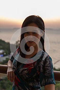 An Asian woman portrait at the hotel with happiness and sunset time in the Pattaya beach, Thailand
