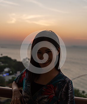 An Asian woman portrait at the hotel with happiness and sunset time in the Pattaya beach, Thailand