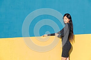 Asian woman posing on a yellow and blue background