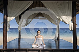 Asian woman practice yoga at luxury beach resort