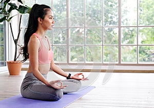 Asian woman practice yoga meditation exercise at home, Young asia female sitting on mat for relaxed yoga posture in the morning ,