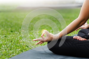 Asian woman practicing yoga in Root Bond, Mula Bandha pose on the mat in outdoor park