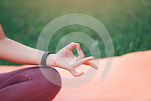 Asian woman practicing yoga in Root Bond  Mula Bandha pose on the mat in outdoor park