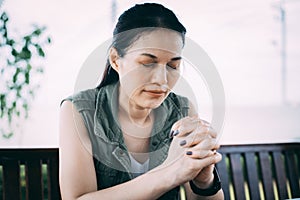 Asian woman praying morning outdoor, Hands folded in prayer concept for faith, spirituality and religion, Church services online