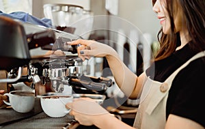 Asian woman professional barista using drip machine uniform to make hot coffee in the morning to serve customers.