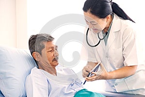 Asian woman professional doctor with clipboard visiting, talking, and diagnosing the old man patient at the hospital