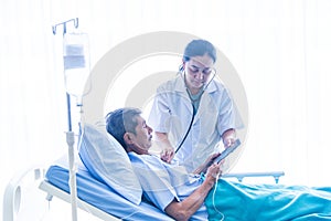 Asian woman professional doctor with notepad smiling, consulting, talking, and diagnosing the old man patient