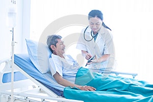 Asian woman professional doctor with notepad smiling, consulting, talking, and diagnosing the old man patient