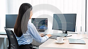 Asian woman programmer typing source code with computer pc for Developing program or application in her office