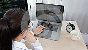 Asian Woman programmer typing source codes Programming On Computer in office, freelance web developer concept