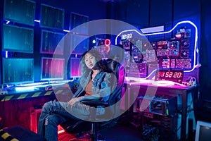 Asian woman programmer is working in her computer room , futuristic technology concept
