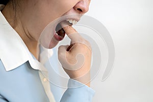 Asian woman putting her fingers in her mouth to throw up after eating food,obsessive desire to lose weight,female sticking her