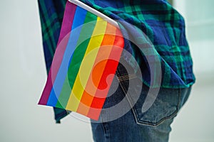 Asian woman with rainbow flag, LGBT symbol rights and gender equality, LGBT Pride Month in June