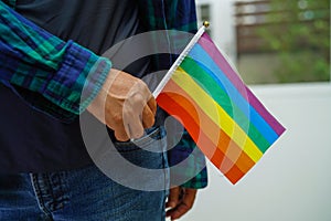 Asian woman with rainbow flag, LGBT symbol rights and gender equality, LGBT Pride Month in June