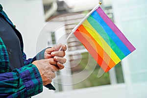 Asian woman with rainbow flag, LGBT symbol rights and gender equality, LGBT Pride Month in June