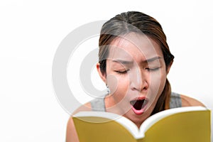 Asian woman reading book and gape feel sleepy on white background, Selective focus, Face expression concept photo