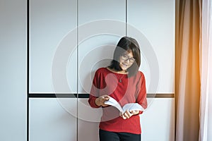 Asian woman reading a book standing feelling happy and relax