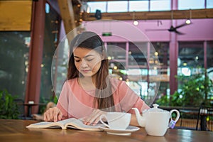 Asian woman reading books and drink hot tea