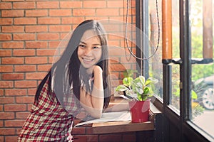 Asian Woman reading newspaper in office and smile as background