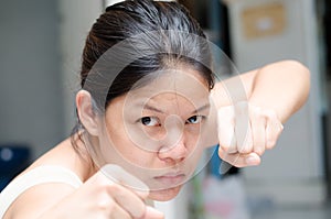 Asian woman ready to fight guarding with empty hand