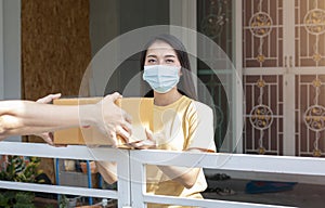 Asian woman receiving package from delivery service