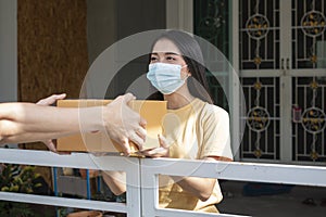 Asian woman receiving package from delivery service