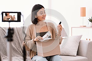 Asian woman recording product review for beauty blog