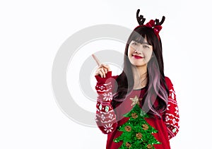 Asian woman in red christmas sweater reindeer horns headband finger pointing