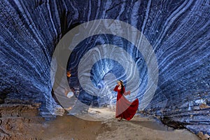 Asian woman in a red dress visits a blue cave in Tak Province, Thailand photo