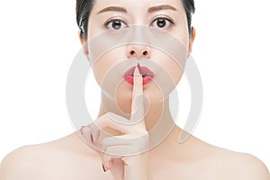 Asian woman red lipstick and finger showing hush silence sign