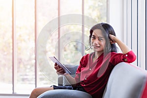 Asian woman in red shirt using tablet computer