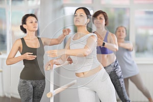 Asian woman refining ballet technique with emale instructor