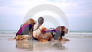 Asian woman relaxing with dog on the beach. Golden Retriever recreation and lifestyle on summer holiday