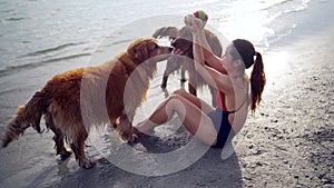 Asian woman relaxing with dog on the beach. Golden Retriever recreation and lifestyle on summer holiday