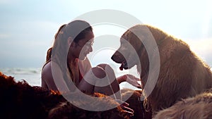 Asian woman relaxing with dog on the beach. Golden Retriever recreation and lifestyle on summer holiday