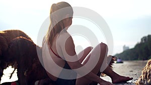 Asian woman relaxing with dog on the beach. Golden Retriever recreation and lifestyle on summer holiday